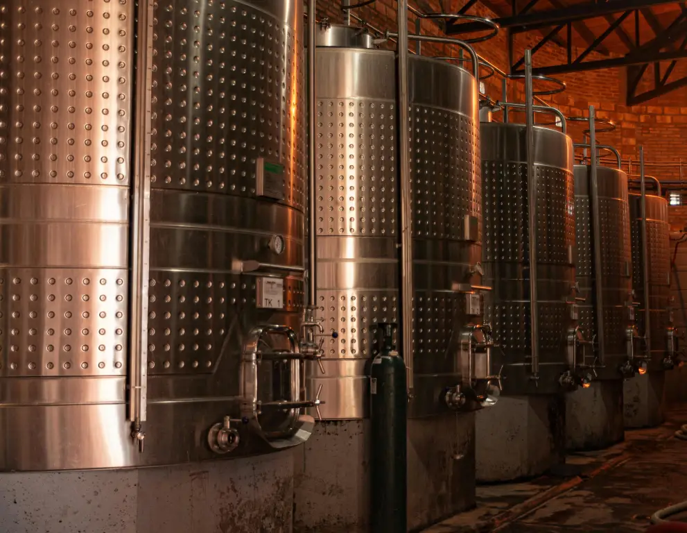 A row of large metal tanks in a room.