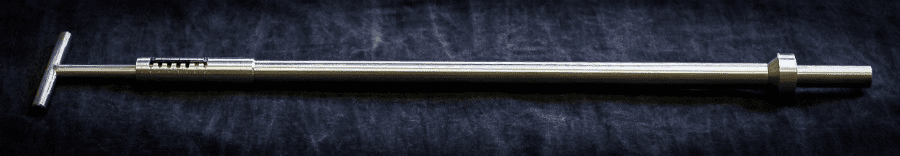 Stainless steel tool on dark background.