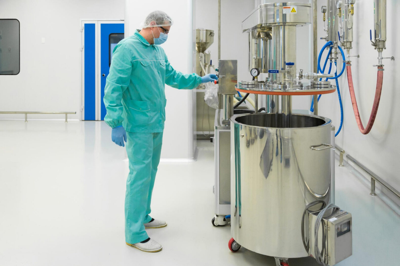 Lab technician operating stainless steel mixing tank
